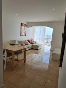 a living room with a table and a couch at Casa da Praia da Costa in Costa da Caparica