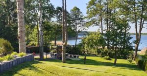 a backyard with a hammock and a view of the water at Stacja Mazury(Masuria Station) in Narty