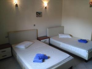 two beds in a room with blue towels on them at View and Relax Apartment in Plataria