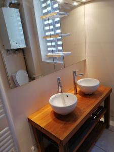 a bathroom with two sinks on a wooden counter at Au Thiernois in Thiers