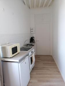 a kitchen with a microwave on top of a counter at Au Thiernois in Thiers