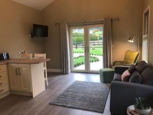 a living room with a couch and a sliding glass door at The Lodge - Rural Tipperary bordering Kilkenny 