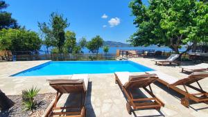 a swimming pool with two lounge chairs and a swimming pool at Paleros View Inn in Paleros