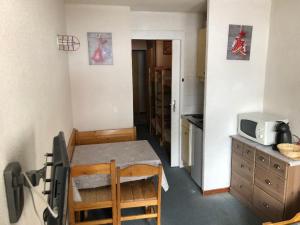 a small kitchen with a table and a microwave at Residence Chalet club Valfréjus in Modane