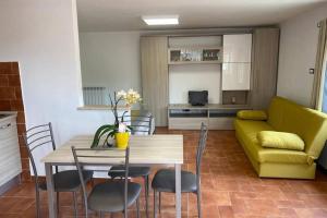 sala de estar con mesa y sofá amarillo en Alloggio a via Impero en Lenola