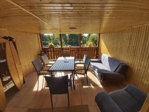 a screened in porch with a table and chairs at Fenyőfa vendégház in Szilvásvárad