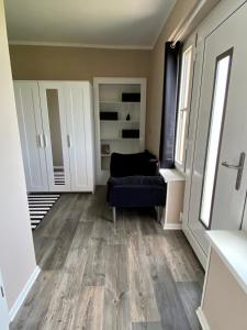 a living room with a blue couch and wooden floors at Ferienwohnung PuraVida Ostsee 5A in Kühlungsborn