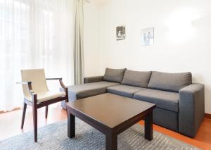 ein Wohnzimmer mit einem Sofa, einem Tisch und einem Stuhl in der Unterkunft Baltic Park Plaza by Baltic Home in Świnoujście