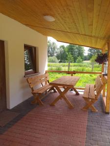 PozezdrzeDomki na Mazurach -Pieczarki的天井上设有野餐桌和2张长椅