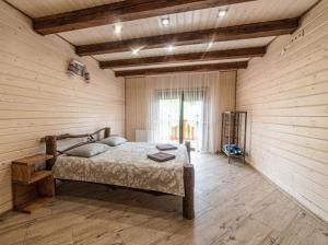 a bedroom with a bed in a room with wooden walls at Villa Grace in Oryavchyk