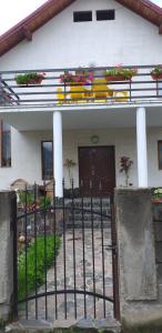 uma casa com um portão com flores em Vila Felicia em Borşa