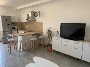 een keuken met een flatscreen-tv op een aanrecht bij "Antre Nous" au Cœur de Lunel in Lunel