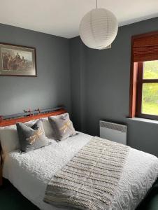 1 dormitorio con 1 cama con edredón blanco y ventana en The Dornie, en Dornie