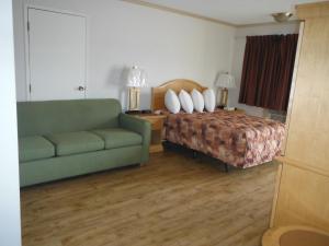 a hotel room with a bed and a couch at Tumbler Ridge Inn in Tumbler Ridge