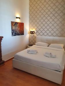 een slaapkamer met een groot wit bed en handdoeken bij Sciala' 2 in Taormina