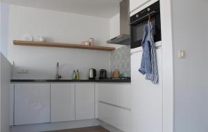 a kitchen with white cabinets and a stove at The Blue Whale in Bergen aan Zee