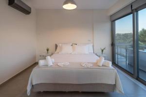 1 dormitorio con 1 cama grande y toallas. en Αnemi apartments, en Finikounta