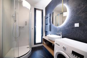 a bathroom with a sink and a shower and a mirror at Aparthotel Inspire Miodova Residence in Kraków