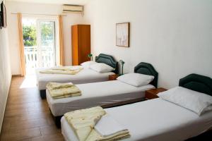 a group of four beds in a room at Guest House Galija in Budva