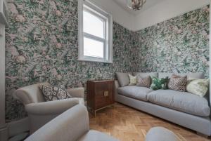 a living room with a couch and floral wallpaper at Stattons Boutique Hotel & Restaurant in Portsmouth