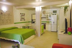 a bedroom with a green bed and a kitchen at Casa "Dolina Kraljevac" in Kraljevac Križevački