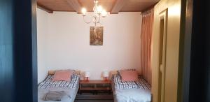Habitación con 2 camas, mesa y lámpara de araña. en Na Zamkniętej, en Ostróda