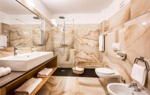 Un baño con lavabo, inodoro y espejo. en Parc Hotel Miramonti, en Fiè