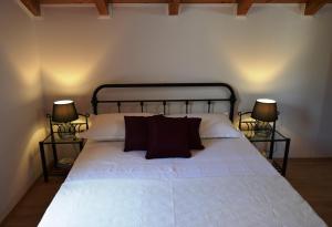 a bedroom with a white bed with two lamps at Two-Bedroom House with Shared Pool in heart of Seget in Trogir