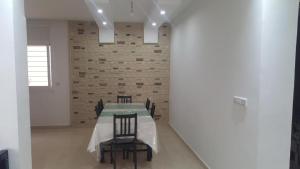 a dining room with a table and chairs and a brick wall at La perle de saidia in Saidia 