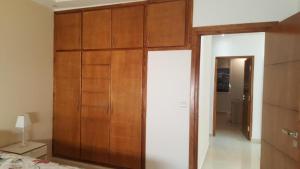 a room with a large wooden cabinet in a bedroom at La perle de saidia in Saidia  +4 photos