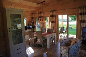 a living room with a dining room table and chairs at Ferienhäuser Seeblick in Langenhagen