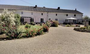 a large white house with flowers in the yard at Le Vieux Logis in Montreuil-Bellay