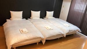 a large white bed with two pillows on it at THE LANG HOTEL Hakata in Fukuoka