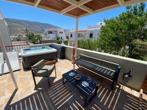 a patio with a bench and a hot tub at Andros 4 All Seasons Villas & Suites in Andros