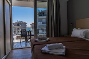 a hotel room with a bed and a balcony with a view at Novelrooms in Paralia Katerinis