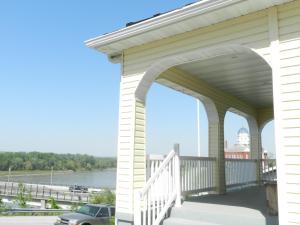 a porch with a white railing and a view of a river at Helming Guest House in Hermann