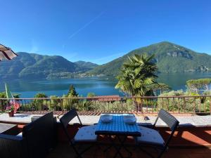 uma mesa e cadeiras num pátio com vista para um lago em Cosy Penthouse with stunning view on Lugano Lake em Cima