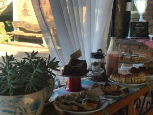 a table topped with different types of food on plates at Pousada Quinta do Barao in Conceição da Ibitipoca