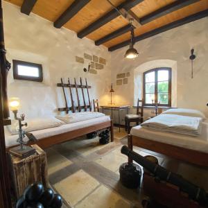 a bedroom with two beds and a table in a room at Fewo WAFFENKAMMER im Rittergut Leppersdorf bei Dresden für 7 Personen in Leppersdorf