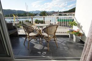 eine Terrasse mit einem Tisch und Stühlen auf dem Balkon in der Unterkunft Apartment Fabry Riva Ploče in Ploče