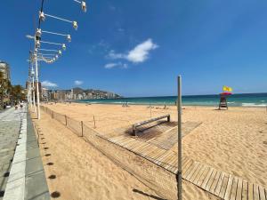 
a beach with a fence and some people on it at MAR Benidorm in Benidorm
