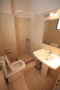 a bathroom with a toilet and a sink and a shower at Ulrika in Egina