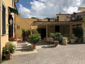 un patio de una casa con macetas. en Hotel Verdesolemare, en Marina di Pietrasanta