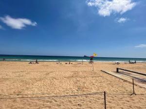a beach with people on the sand and the ocean at MAR Benidorm in Benidorm