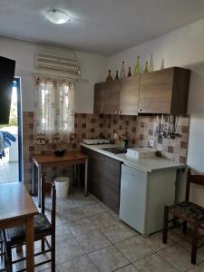 a kitchen with wooden cabinets and a table and chairs at Mylos Garden in Livadi