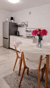a kitchen with a table with a vase of flowers on it at Apartament OLTO Mikołajki in Mikołajki +17 photos