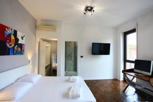 a bedroom with a white bed and a flat screen tv at B&B Allegra in Bologna