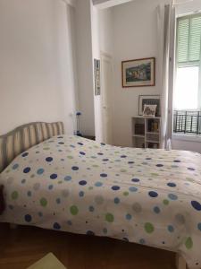 ein Schlafzimmer mit einem Bett mit einer Polka-Dot-Tagesdecke in der Unterkunft Nissa la Bella in Nizza