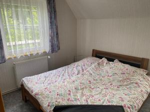 a bedroom with a bed with a floral bedspread at Ferienwohnung Tanja in Lassan