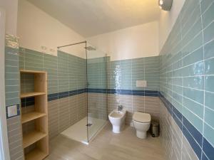 een badkamer met een toilet en een glazen douche bij Appartamento in Costa Smeralda - Bilocale sul mare - Sea View in Olbia
